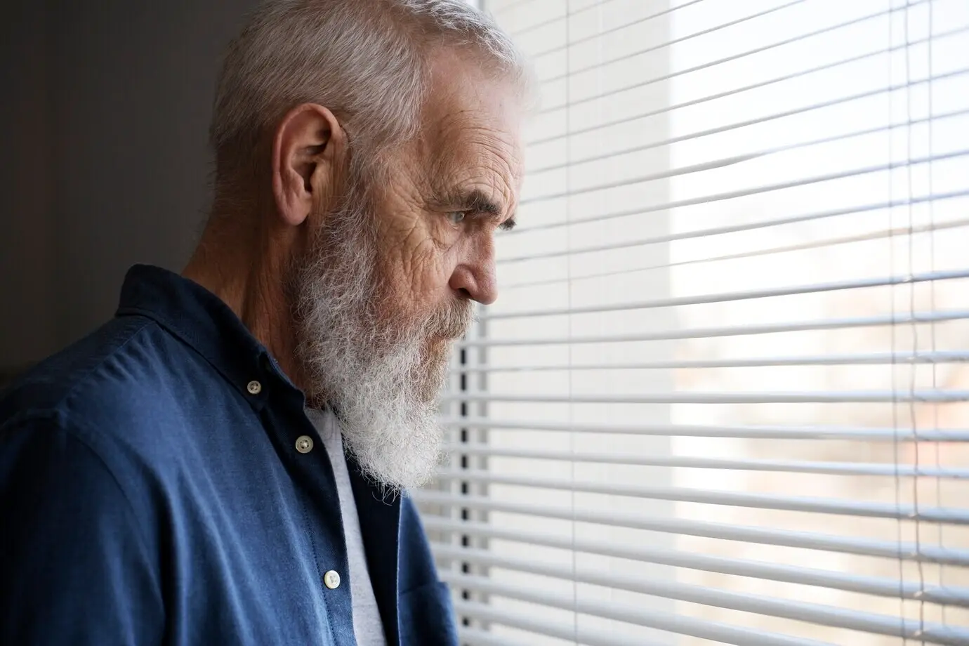 A sad elderly man at home.